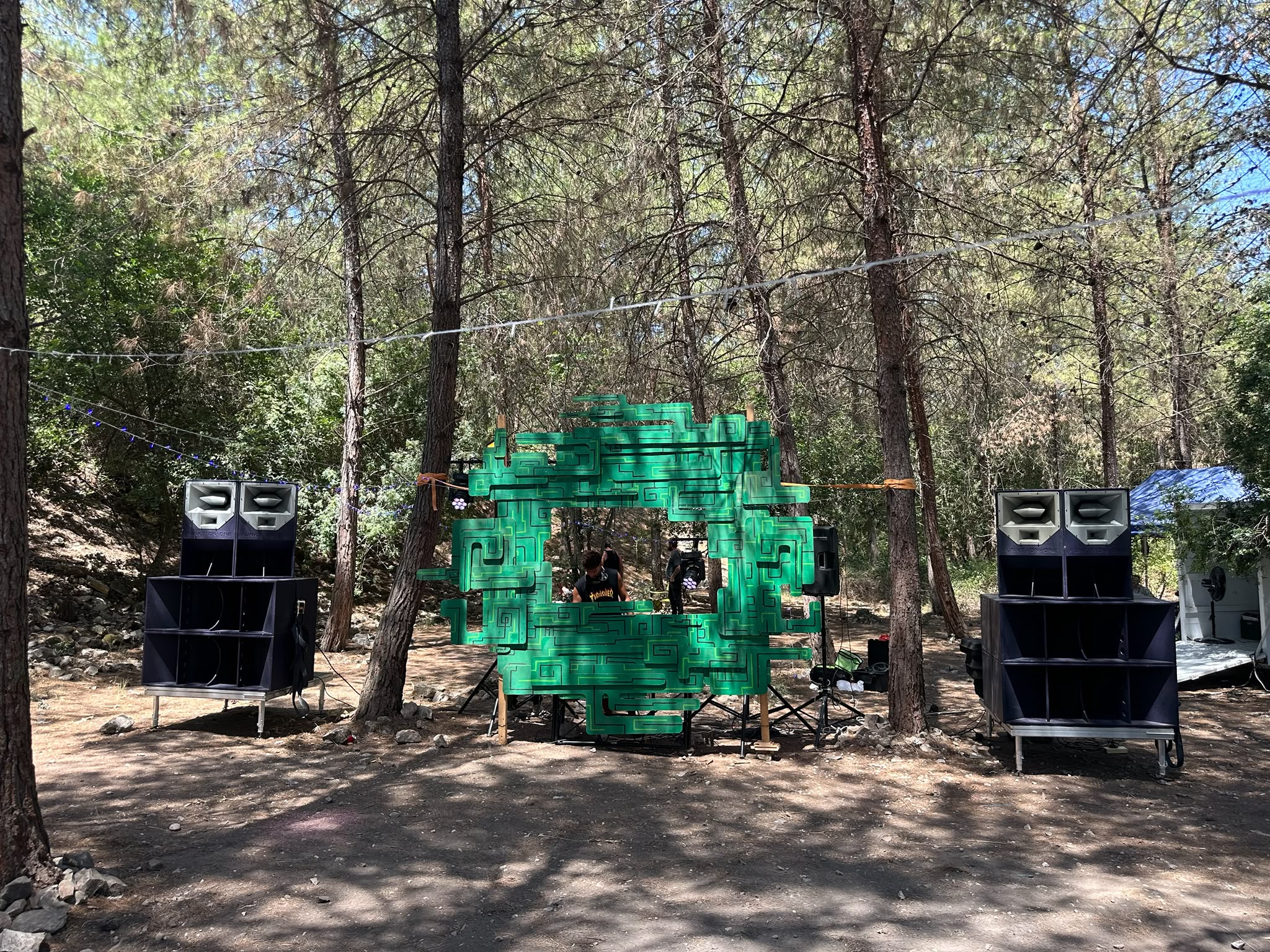 עמדת DJ ירוקה עם מערכת סאונד ביער